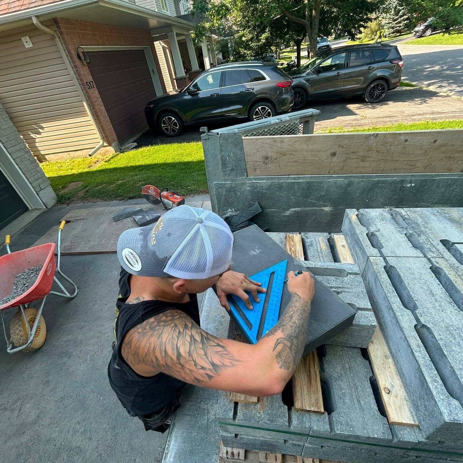 The owner of Gonzo Construction measuring and cutting stone on a job site in Kingston, Ontario